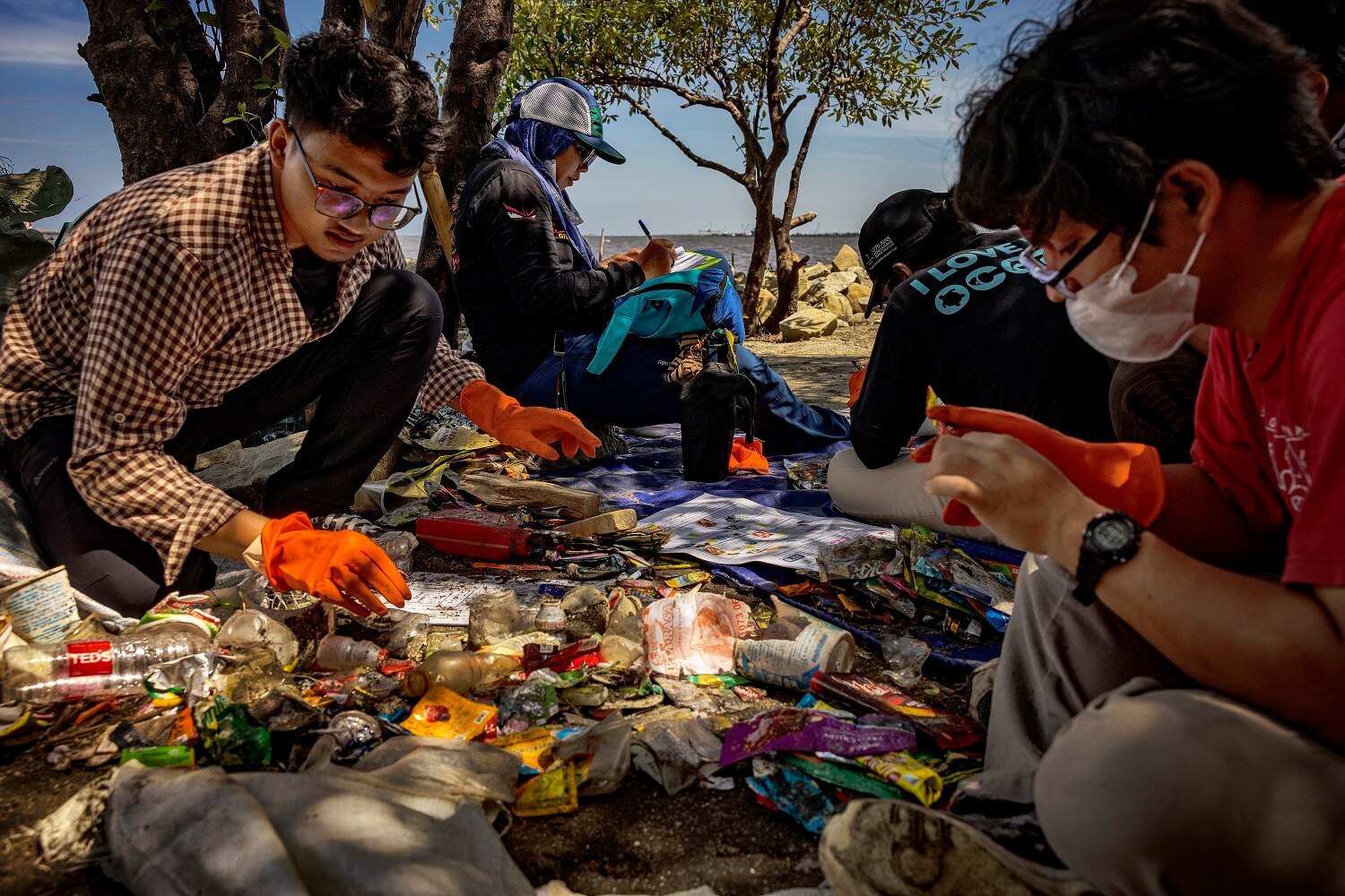 Four people sat around and looked at the pile of plastic waste.
