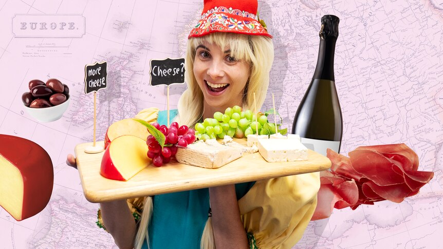 Justina dressed as a European cheese seller holds a cheeseboard of various cheeses.