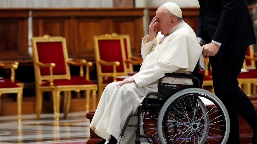 Pope Francis leaves in a wheelchair at the end of a funeral of Cardinal George Pell. 
