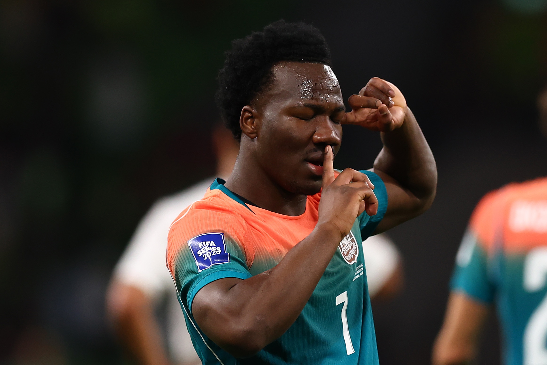 O jogador do Soccerooss, Nestory Irankunda, tem um dedo nos lábios pedindo silêncio e a outra mão apontada para a cabeça