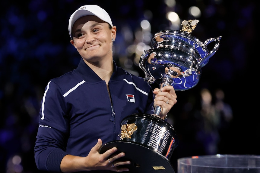 A smiling Ash Barty holds the Daphne Akhurst Memorial Cup after winning the Australian Open final.