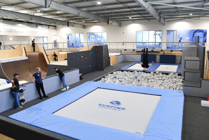 a girl boucing on a trampoline with a board attached to her feet