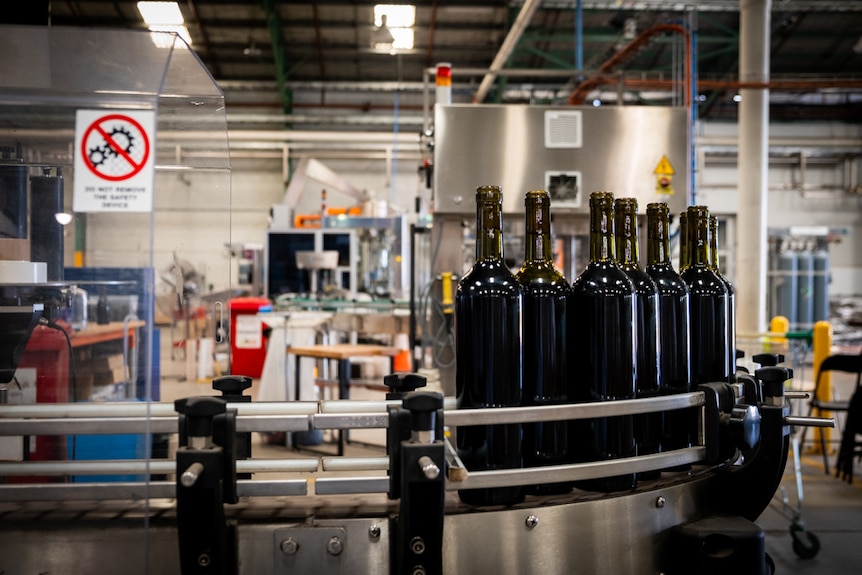 Wine sitting in a labelling machine, inside an Adelaide factory. 