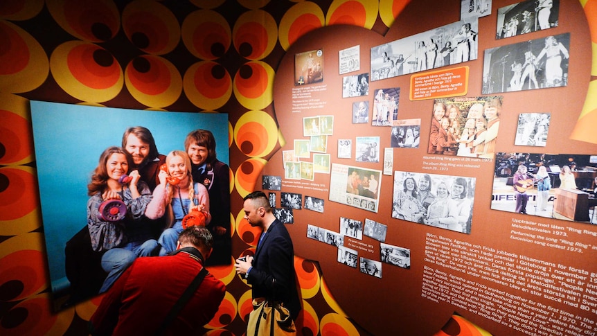 Fans look at photos featuring ABBA at the ABBA museum.