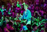 A young man sits on another's shoulders in a crowd at the Falls Festival.