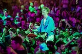 A young man sits on another's shoulders in a crowd at the Falls Festival.