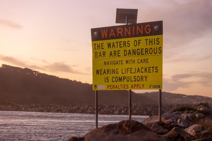 A sign at the entrance of the Bar, warning that waters are dangerous and to wear a life jacket.