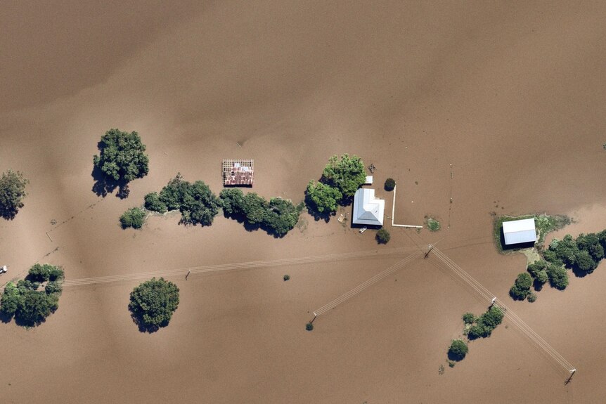 Flooded houses on the swollen Clarence River are submerged, as seen from above.