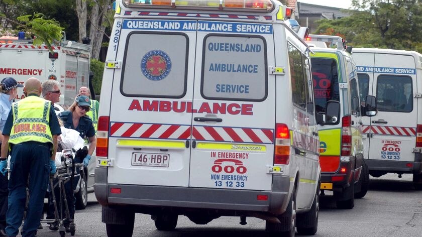 Paramedics with the Queensland Ambulance Service move a patient