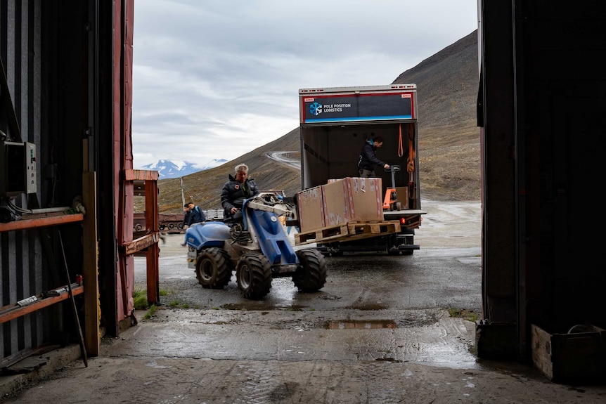 A mini forklift loads up boxes of code at the GitHub code vault in Svalbard.