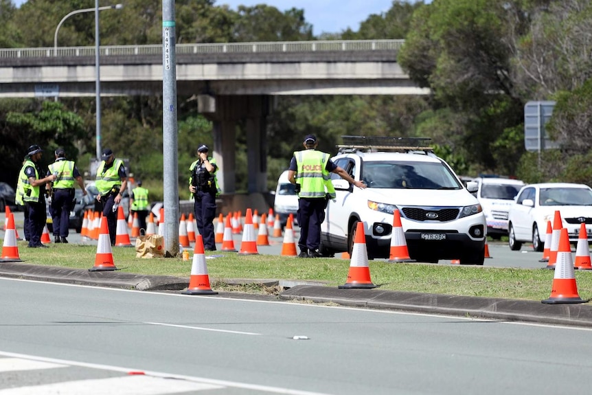 Police officers at checkpoint with driver line-up at Queensland-NSW border at Coolangatta.