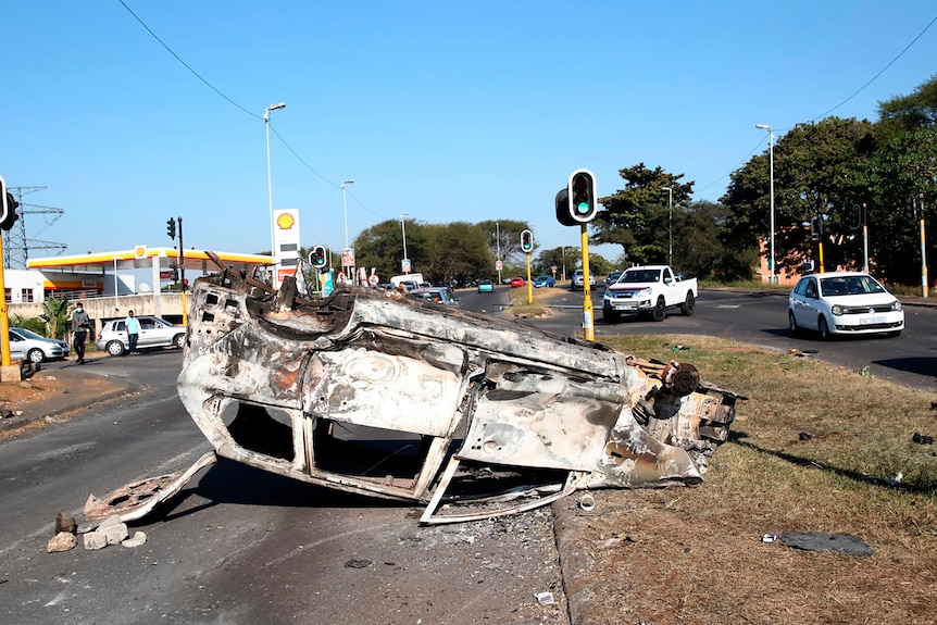 A burnt out vehicle at an intersection in Phoenix, near Durban, South Africa