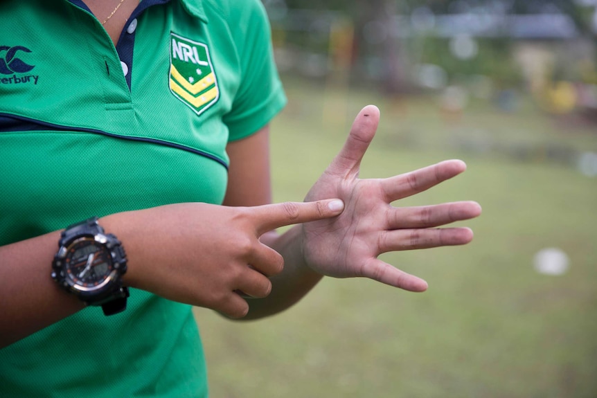 A close-up of Lana's hand performing sign language during a workshop.