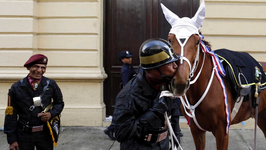 Police officer kisses his horse