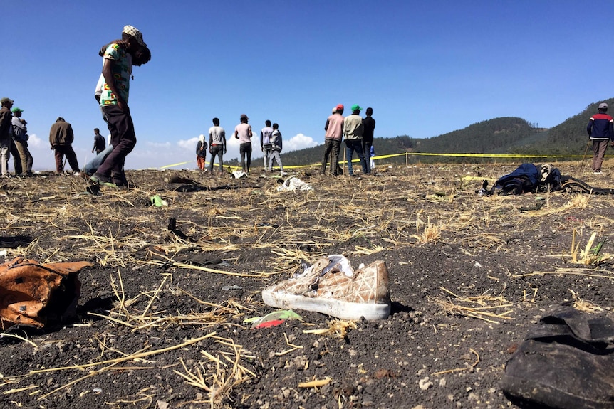 People walk at the scene of the Ethiopian Airlines Flight ET 302 plane crash