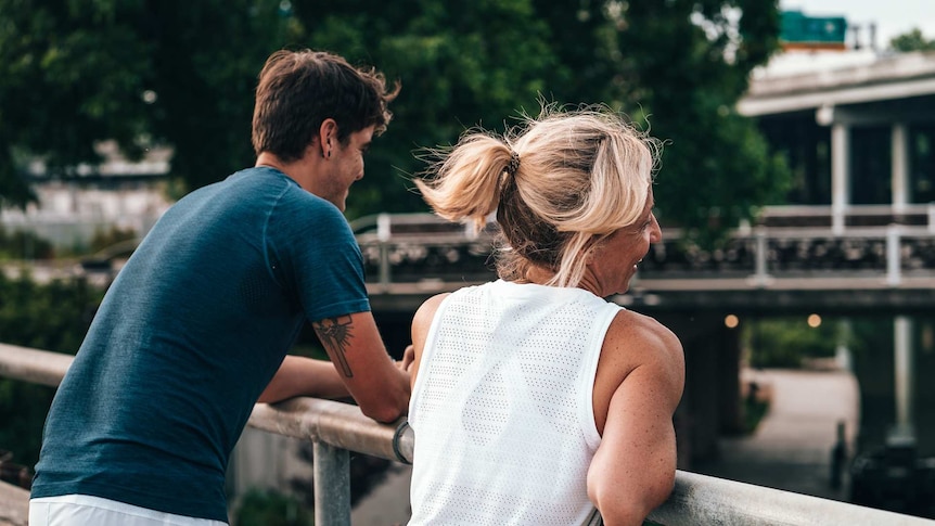 Couple standing on a bridge to depict making your partner your exercise buddy