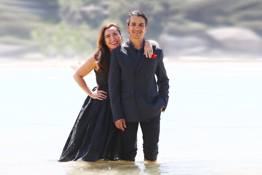 Australian Italian chef Giovanni Pilu and his wife and business partner Marilyn Annecchini, standing in water at the beach.