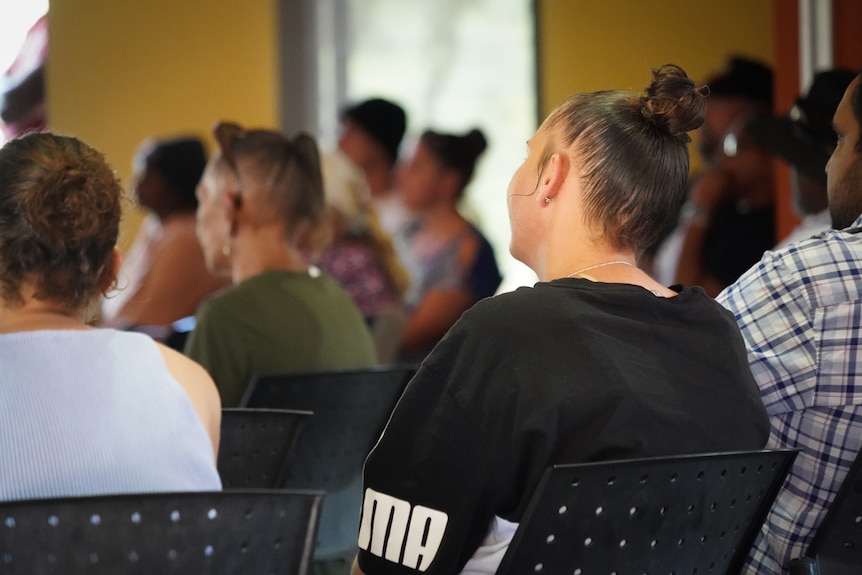 aboriginal women sitting in chairs with their backs turned