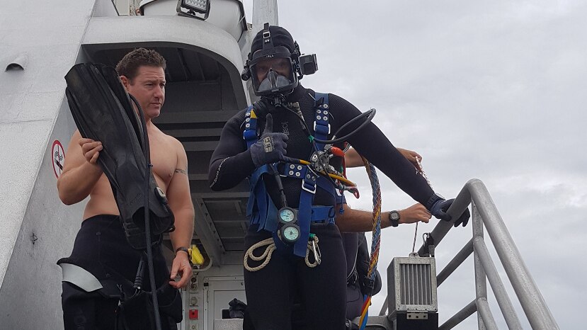 Queensland police diver dressed in diving gear about to enter the water
