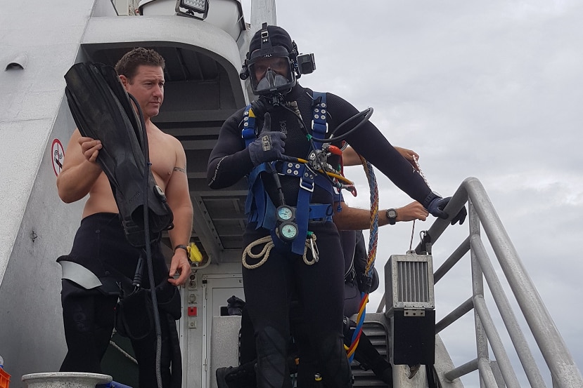 Queensland police diver dressed in diving gear about to enter the water.