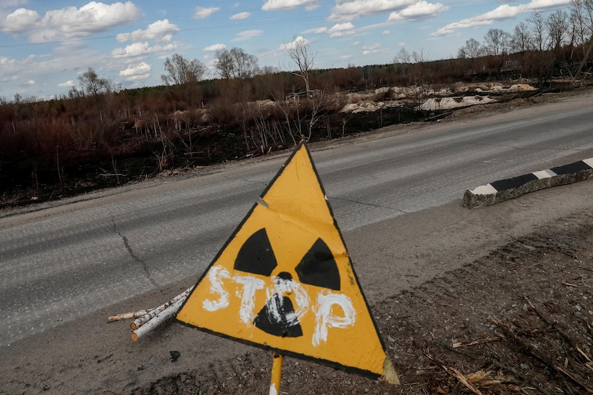 A nuclear warning sign with "STOP" scrawled across it 