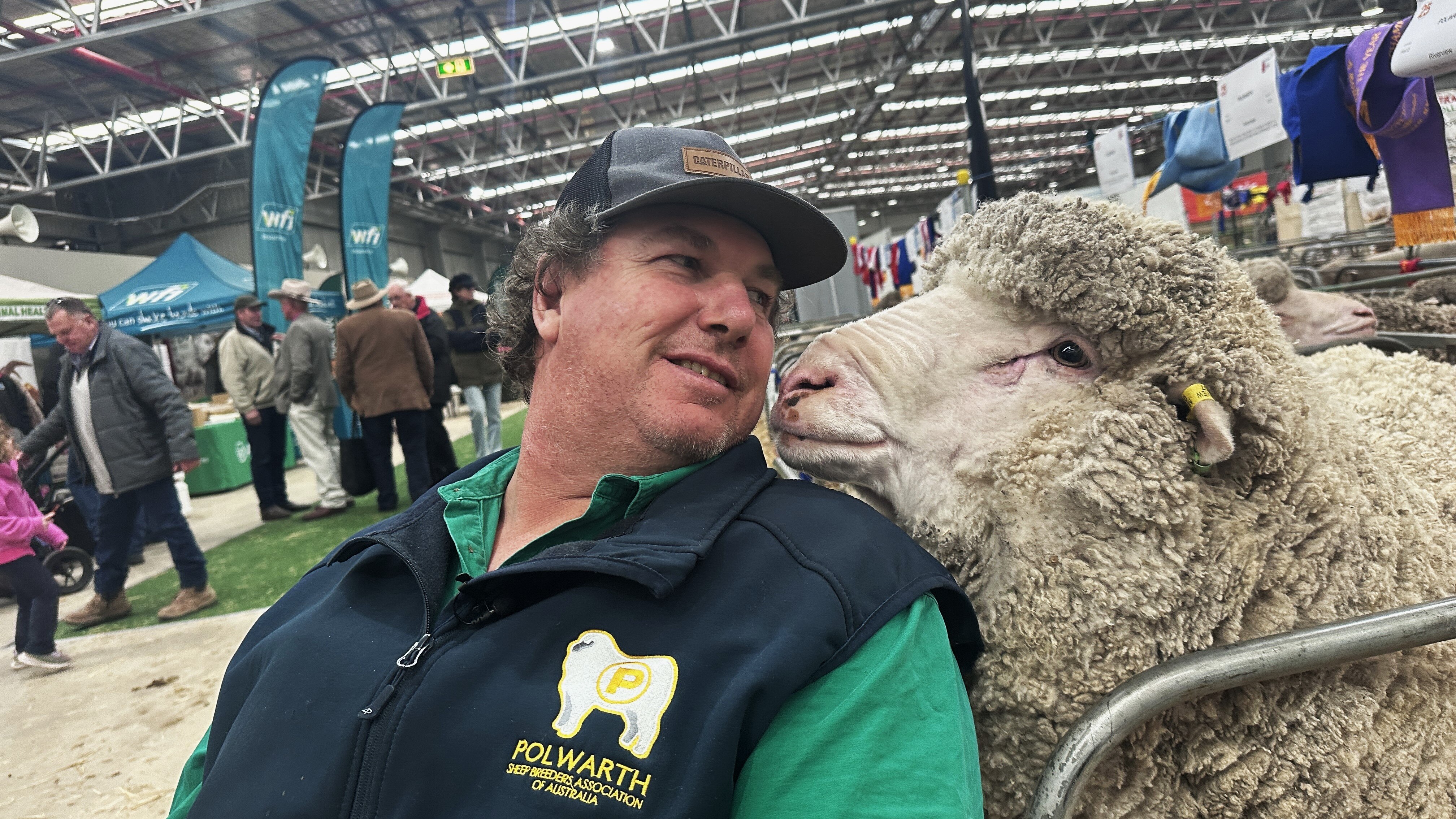 A man looks at a sheep over his shoulder.