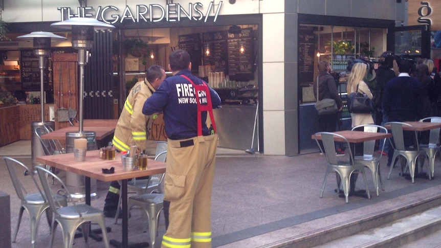 Firefighters gather outside a cafe in the Sydney CBD after a gas stove explosion.