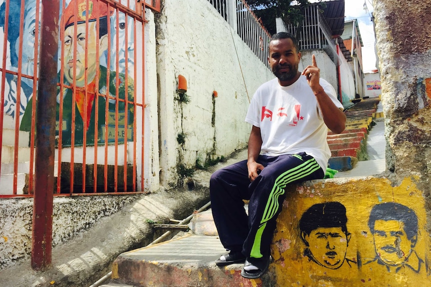 A Venezuelan man sits on a concrete staircase in the barrios of Caracas, Venezuela.