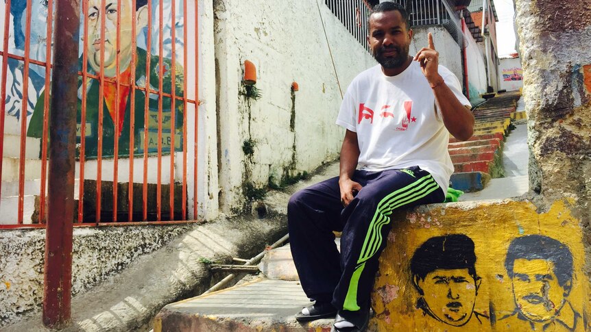 A Venezuelan man sits on a concrete staircase in the barrios of Caracas, Venezuela.