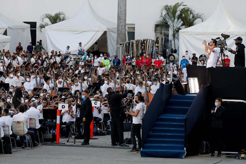 Conductor conducts thosuands  of musicians of Venezuela's National System of Youth Orchestras and Choirs during a concert.