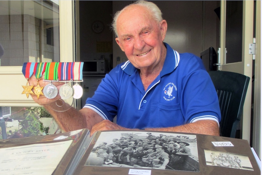 Len Snell with his medals and an album of photographs taken during the war with a box camera given to him by his mother.