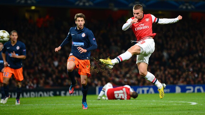 Cracking goal ... Lukas Podolski rasping left foot volley puts Arsenal 2-0 up over Montpellier.