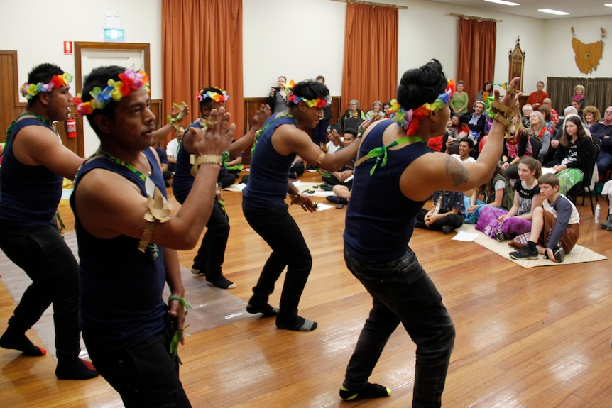 Kiribati dancers dressed in traditional colourful clothing dance for a crowd