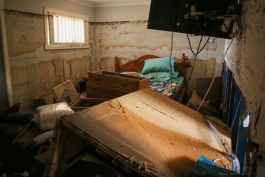 A bedroom which has been completely flooded, after water has receded.