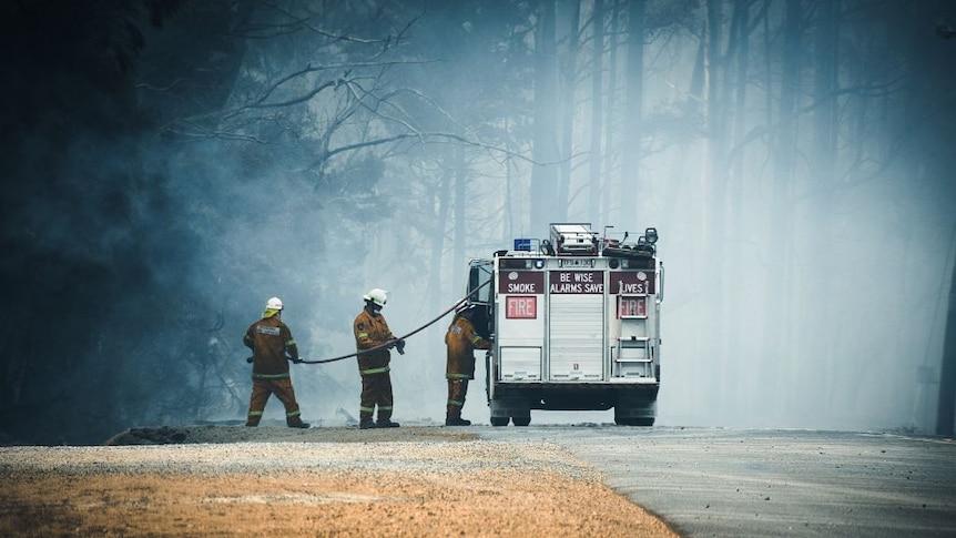 Firefighters at Calder, Tasmania prepare a fire hose