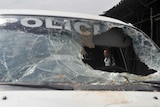 A Colombian police officer observes the damages in the vehicle in which 11 policemen were attacked