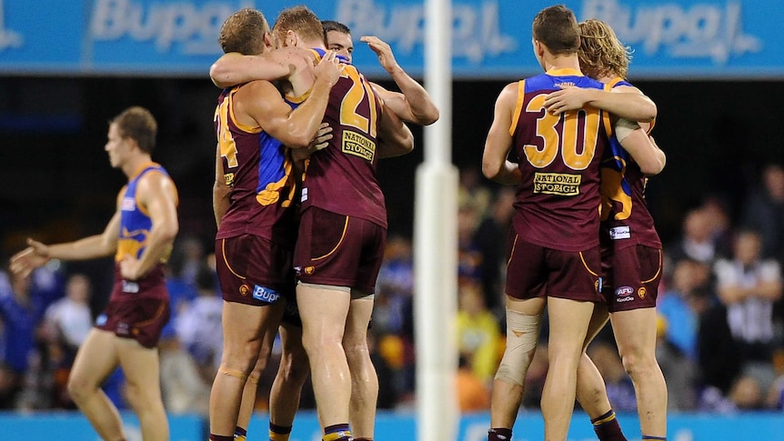 Lions players celebrate victory over the Kangaroos at the Gabba.