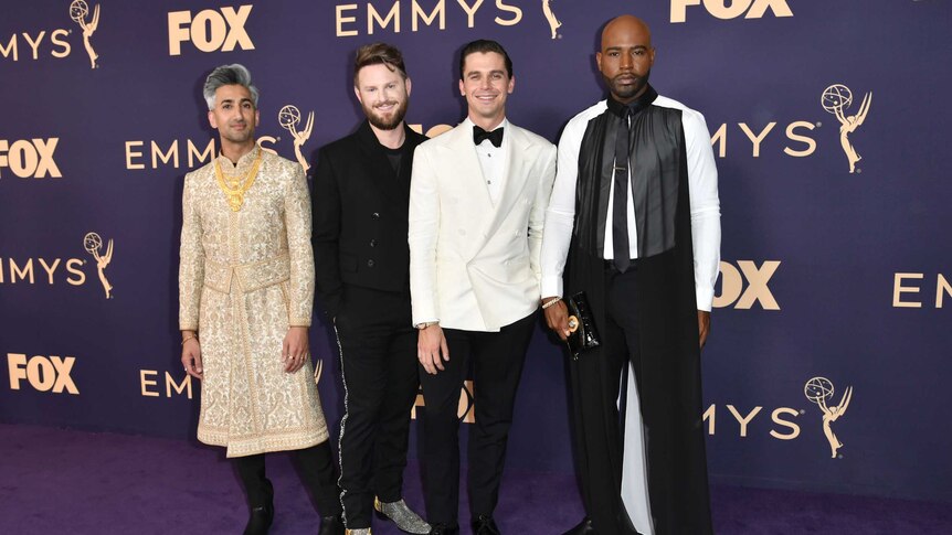 Tan France, Bobby Berk, Antoni Porowski and Karamo Brown stand next to each other against a purple backdrop on the purple carpet