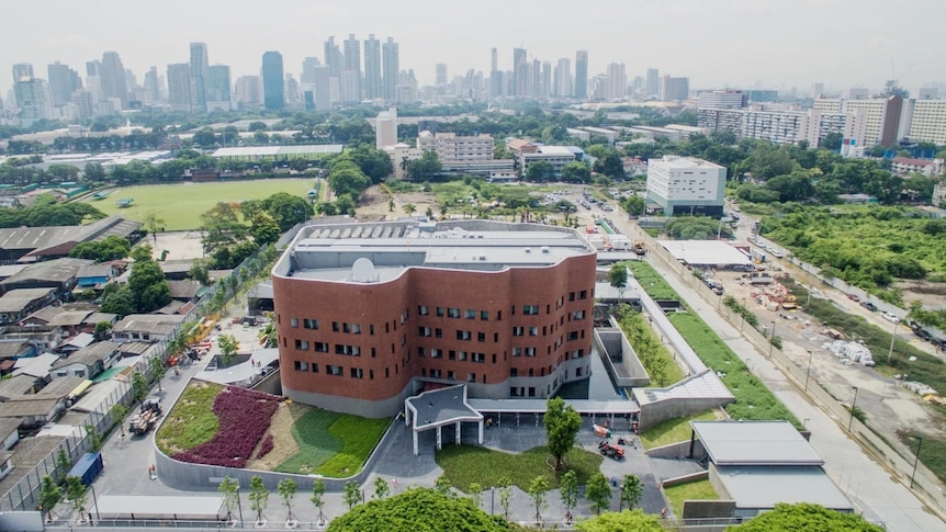 An image of the Australian embassy in Thailand with Bangkok's skyline in the background.