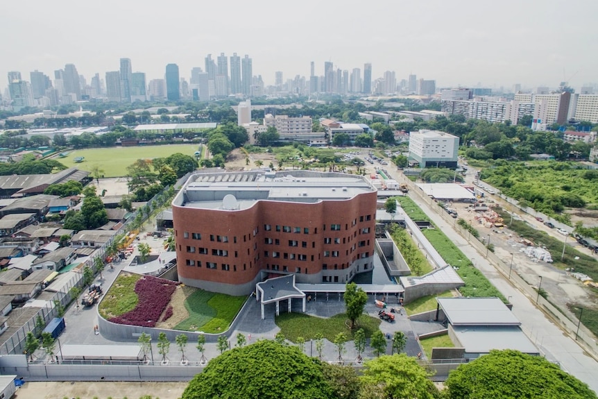 An image of the Australian embassy in Thailand with Bangkok's skyline in the background.