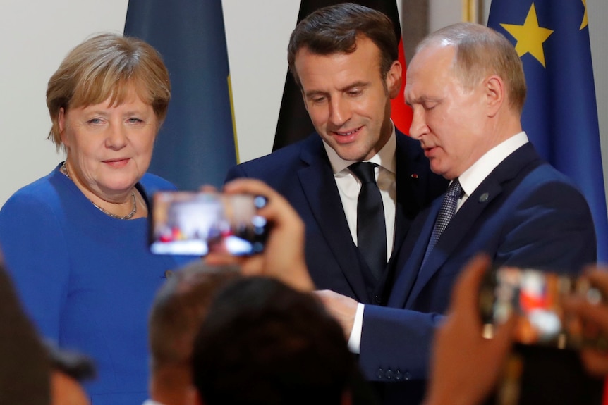 德国前总理默克尔、法国总统马克龙和俄罗斯总统普京一同拍照