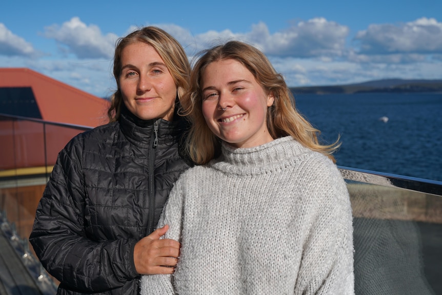 Two 20 year old girls with blonde hair smiling in the sun