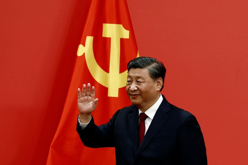   Xi Jinping face semn cu mâna după ce a ținut un discurs.