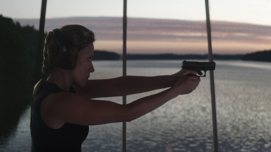 Colour still of Scarlett Johansson practising shooting in scenic room in 2019 film Avengers: Endgame.