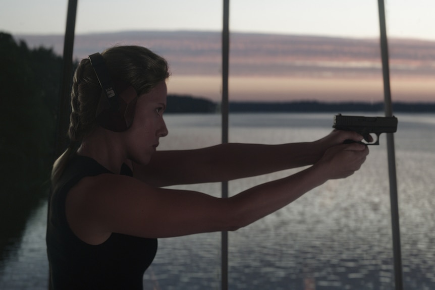 Colour still of Scarlett Johansson practising shooting in scenic room in 2019 film Avengers: Endgame.