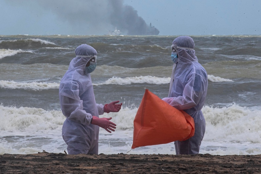 Marinarii din Sri Lanka, în costume de protecție, curăță plaja