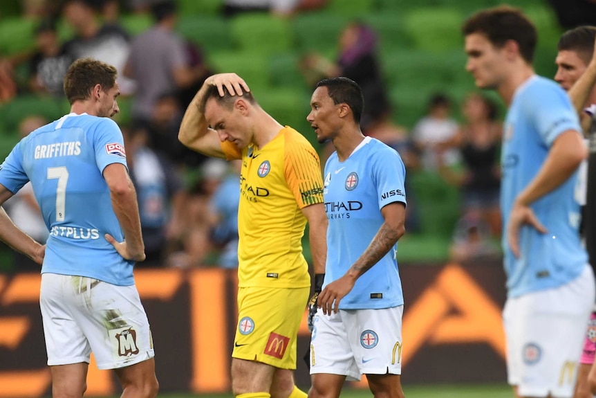 Melbourne City players stand around looking glum.