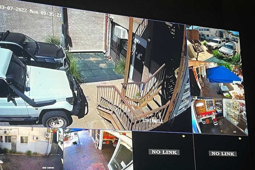 Still images on CCTV monitors, including a ute and the entrance to a business.