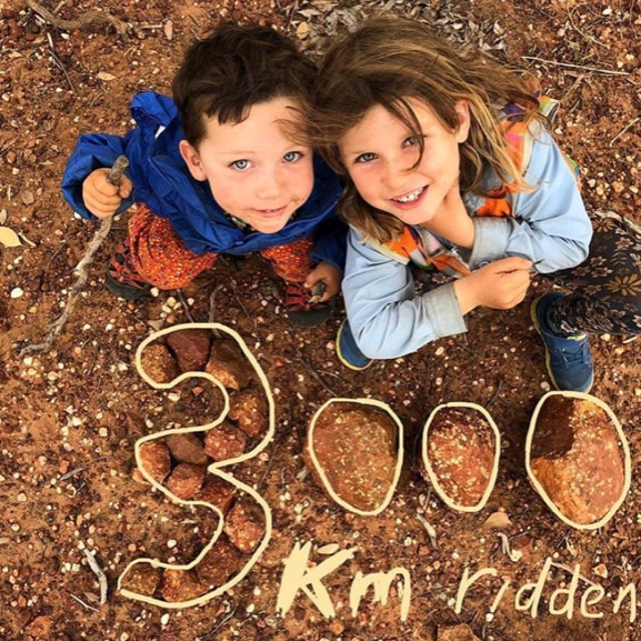 Wilfred and Hope Hughes smile up the camera, and 3000 kilometres is written in rocks under them .