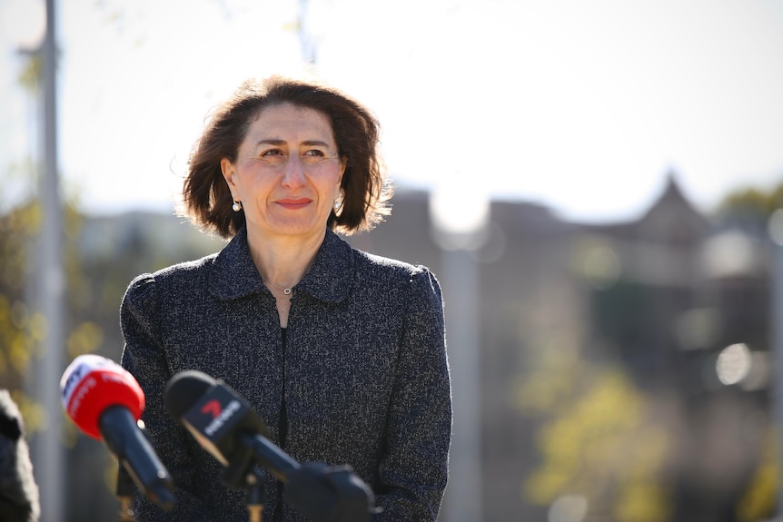 a woman standing behind microphones